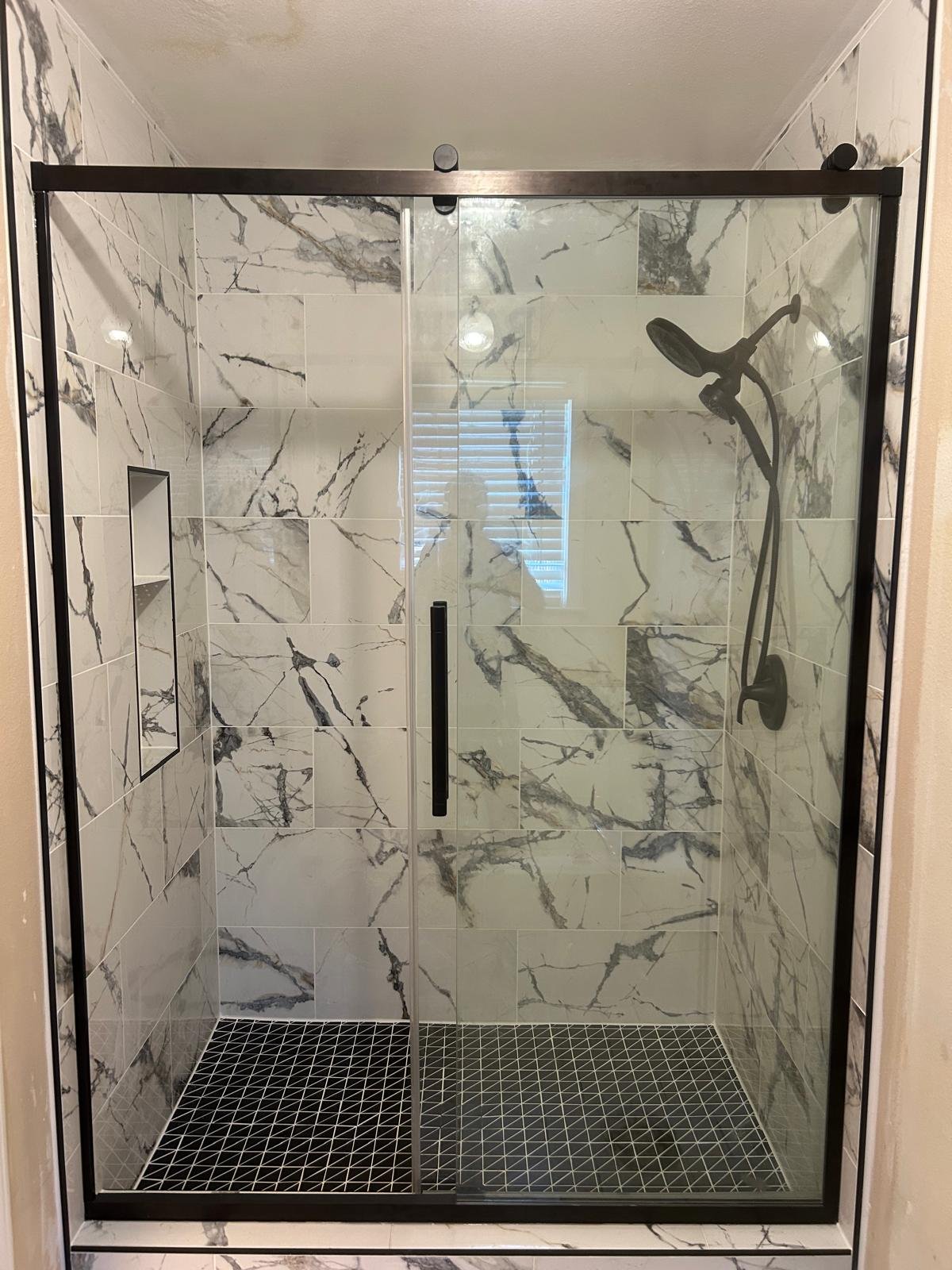 Marble-look shower with mosaic floor