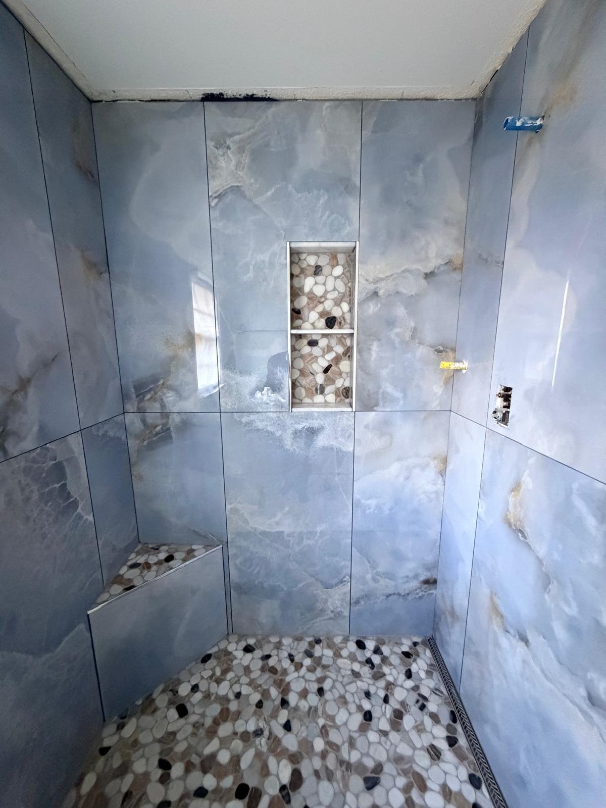 Blue onyx shower with pebble floor
