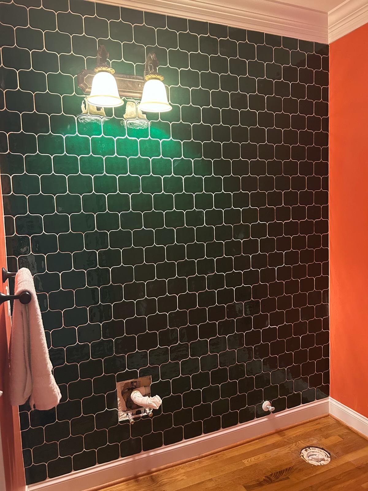 Powder room with green tile accent wall