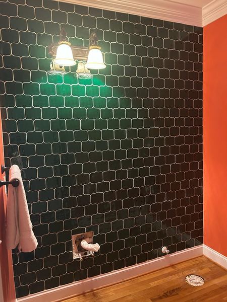 Powder room with green tile accent wall